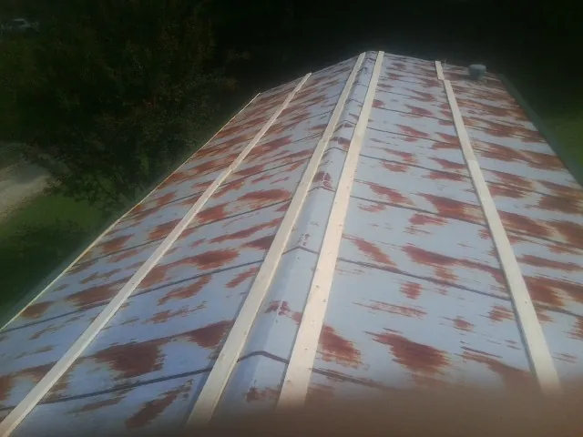 Rusted metal roof panels with new wood purlins before replacement — Storm Damage Roof Repair in Henniker by Roofing Brothers